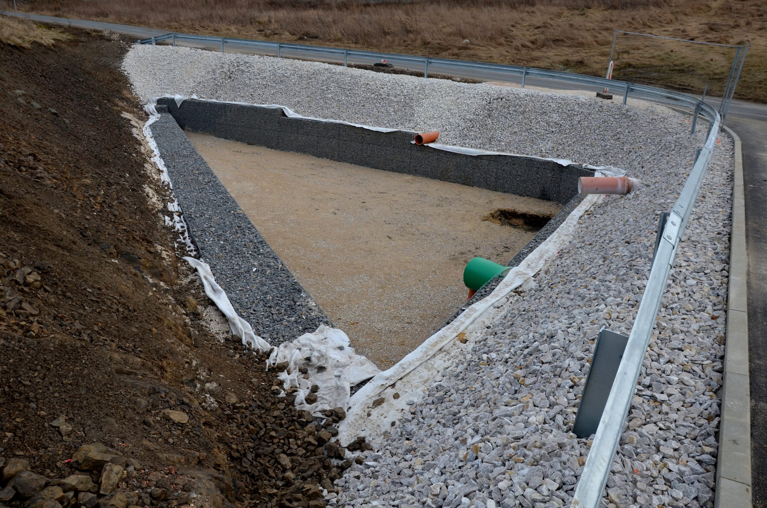 Triangle-shaped,Drainage,Pond,With,Stone,Wall,Paneling,And,Gabion,Walls.